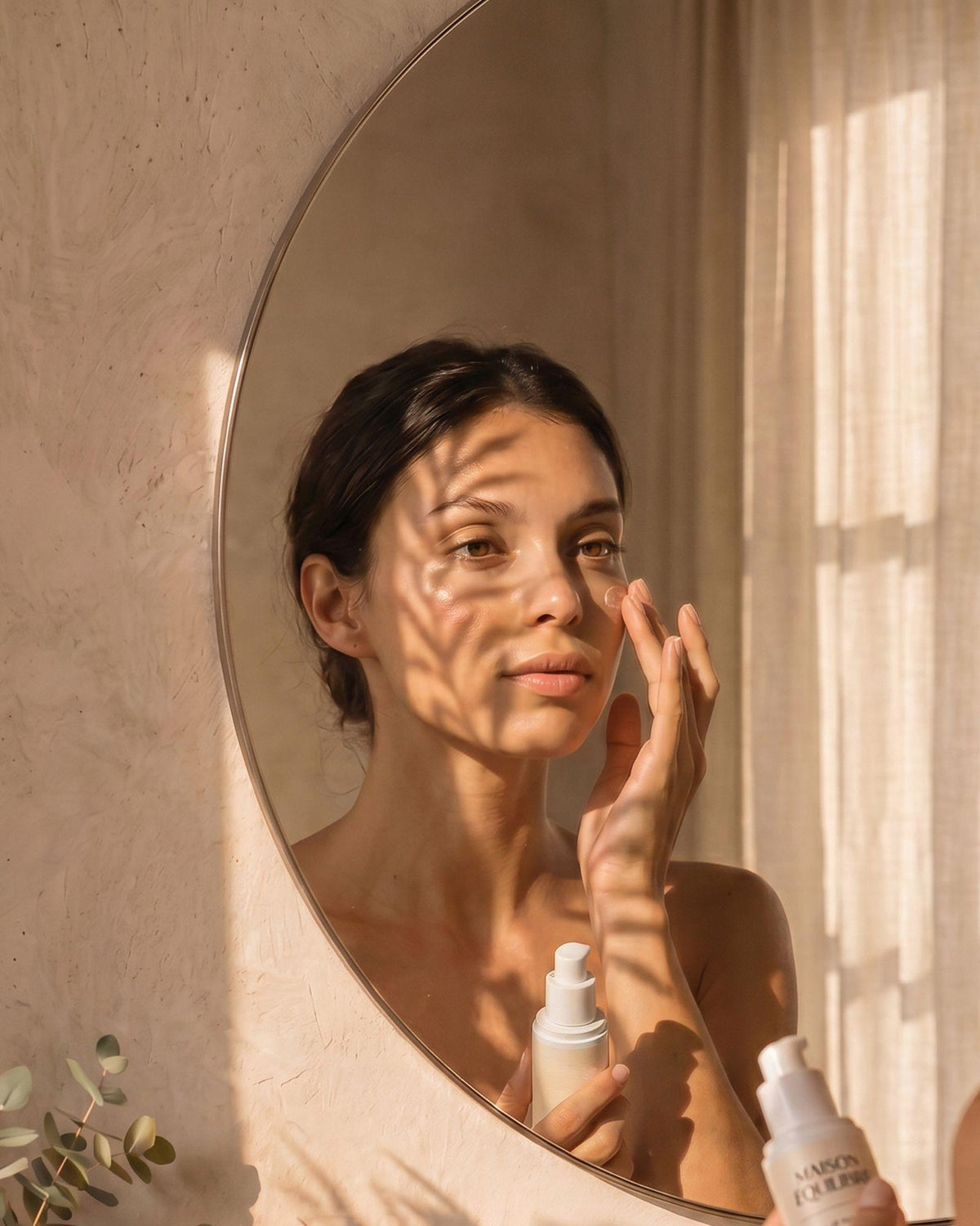 Femme appliquant le sérum Éclat Naturel devant son miroir.