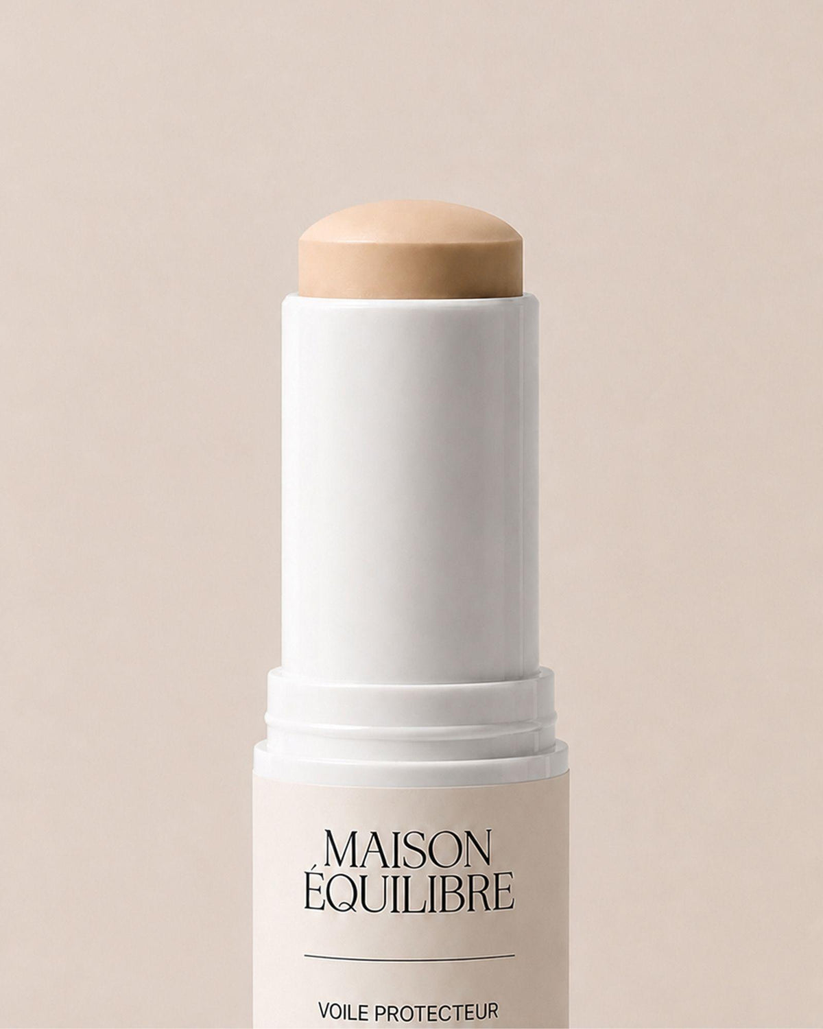Stick solaire SPF 50 Voile Protecteur de Maison Équilibre sur fond beige.