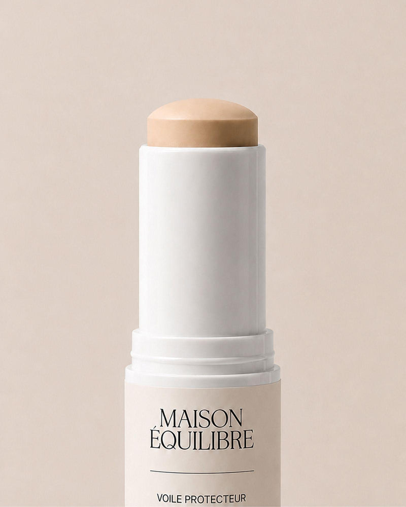 Stick solaire SPF 50 Voile Protecteur de Maison Équilibre sur fond beige.