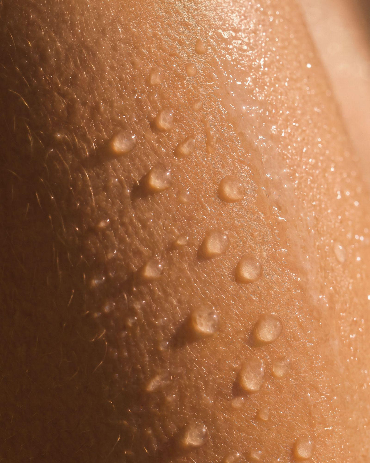 Gouttes d’eau sur la peau pendant l’utilisation du gel douche Peau d’Ambre.