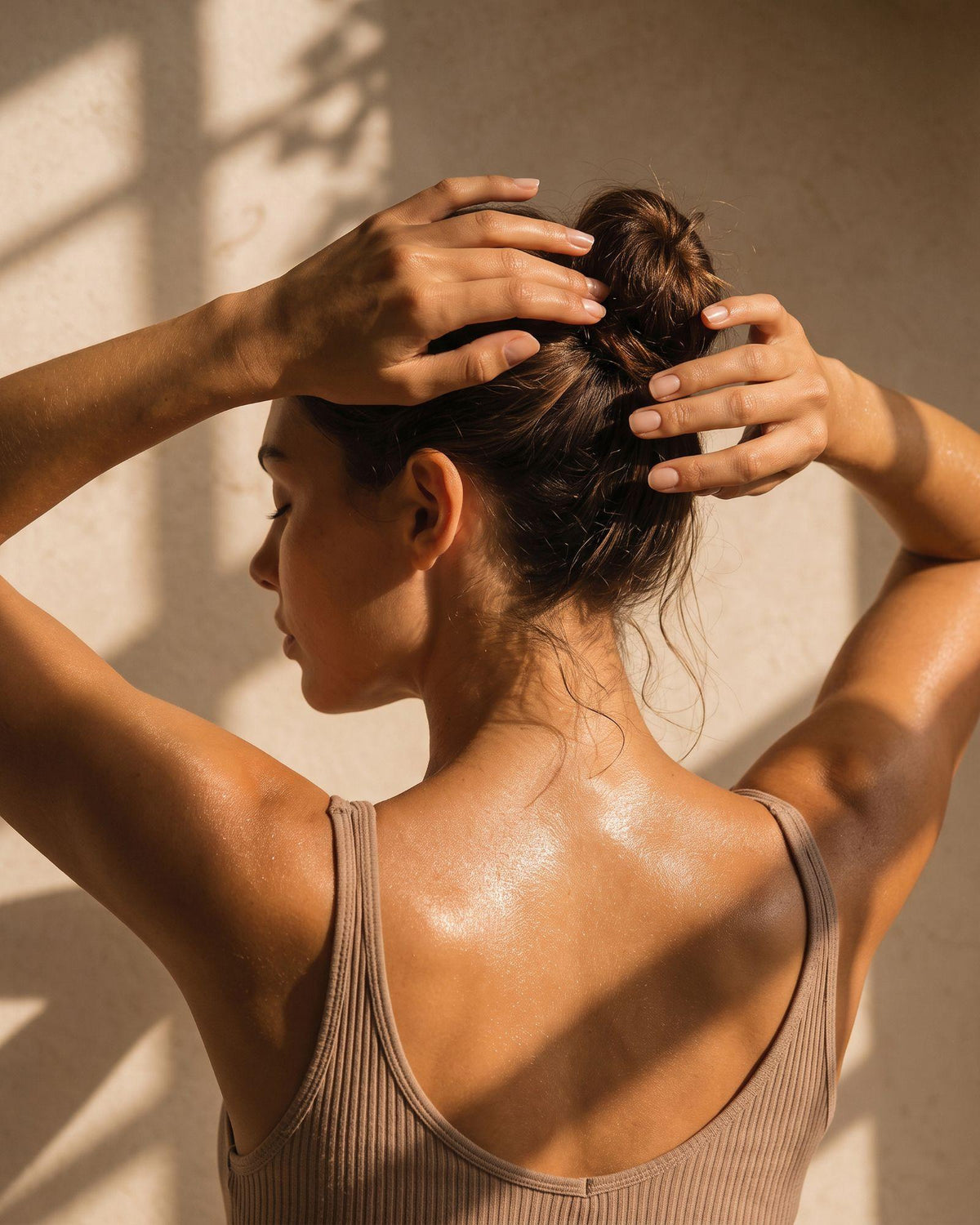 Femme attachant ses cheveux dans une lumière naturelle